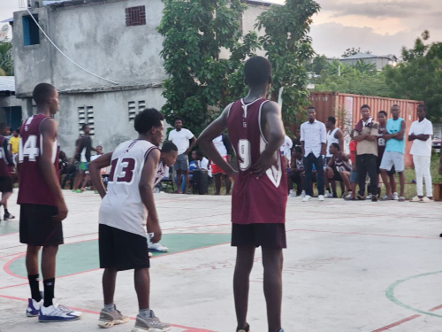 Young basketball players standing on an outdoor court during a school sports competition.
