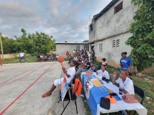 Event organizers and community members overseeing a youth basketball competition in Haiti.