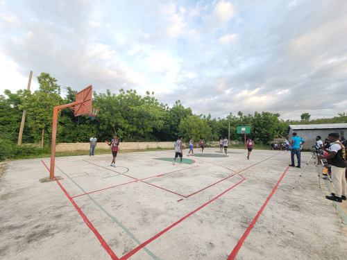 Wide view of an outdoor basketball court during an interschool competition in Anse-à-Veau, Haiti.